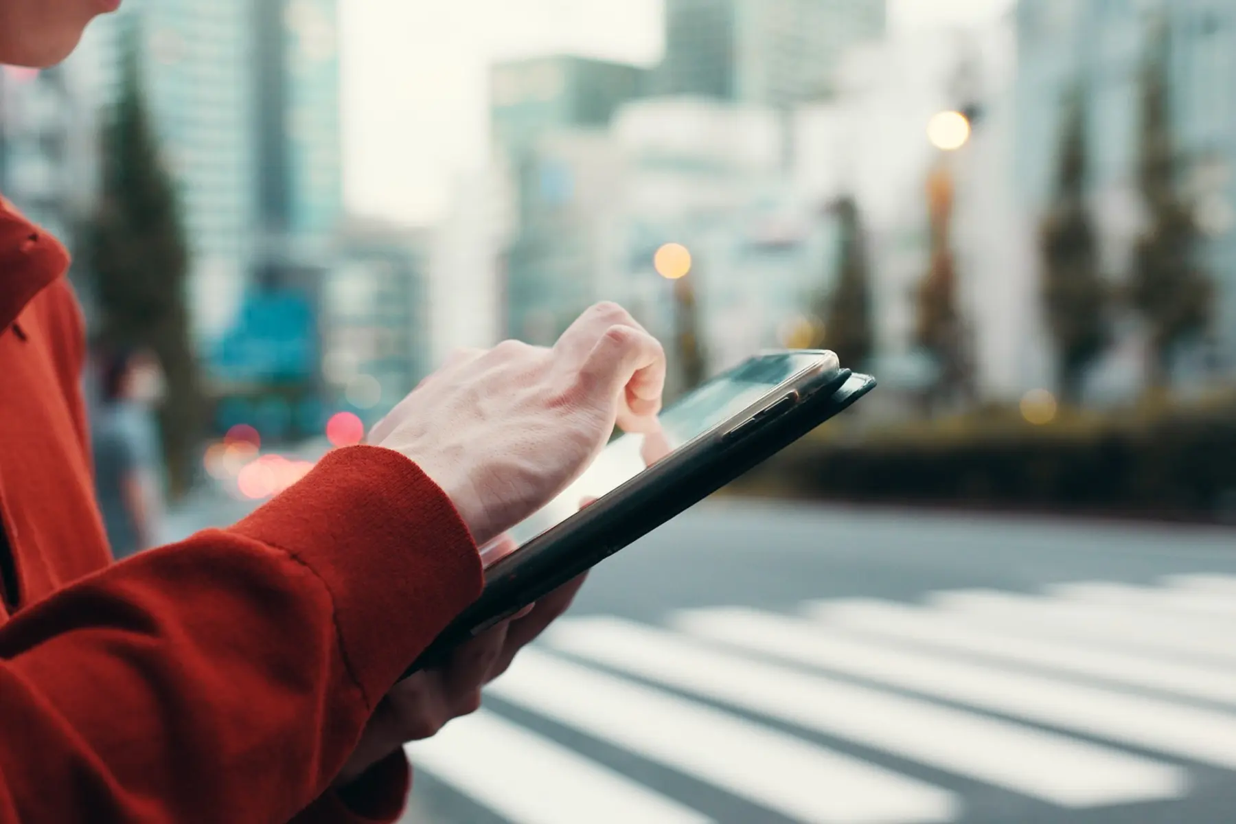 Verifica di dati su dispositivo mobile durante un sopralluogo tecnico in contesto urbano